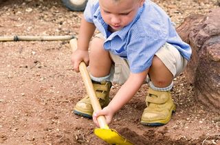 Little boy playing in mud