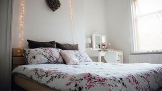 A light blue bedroom with cherry blossom duvet on bed
