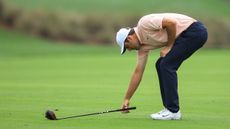 Scottie Scheffler marks out a club-length for a preferred lies placing on the fairway during a PGA Tour event