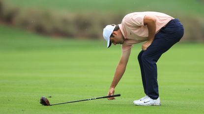 Scottie Scheffler marks out a club-length for a preferred lies placing on the fairway during a PGA Tour event
