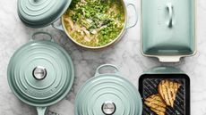 Le Creuset Sage Signature cast iron cookware collection on a sage background