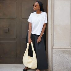 @tiffanymsipa wearing white t-shirt, black maxi skirt, and pale yellow handbag