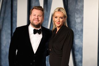 James Corden and Julia Carey posing on the red carpet of the 2023 Vanity Fair Oscars party