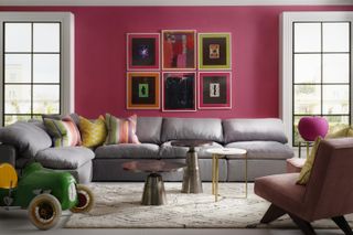 A living room with a bright pink accent wall