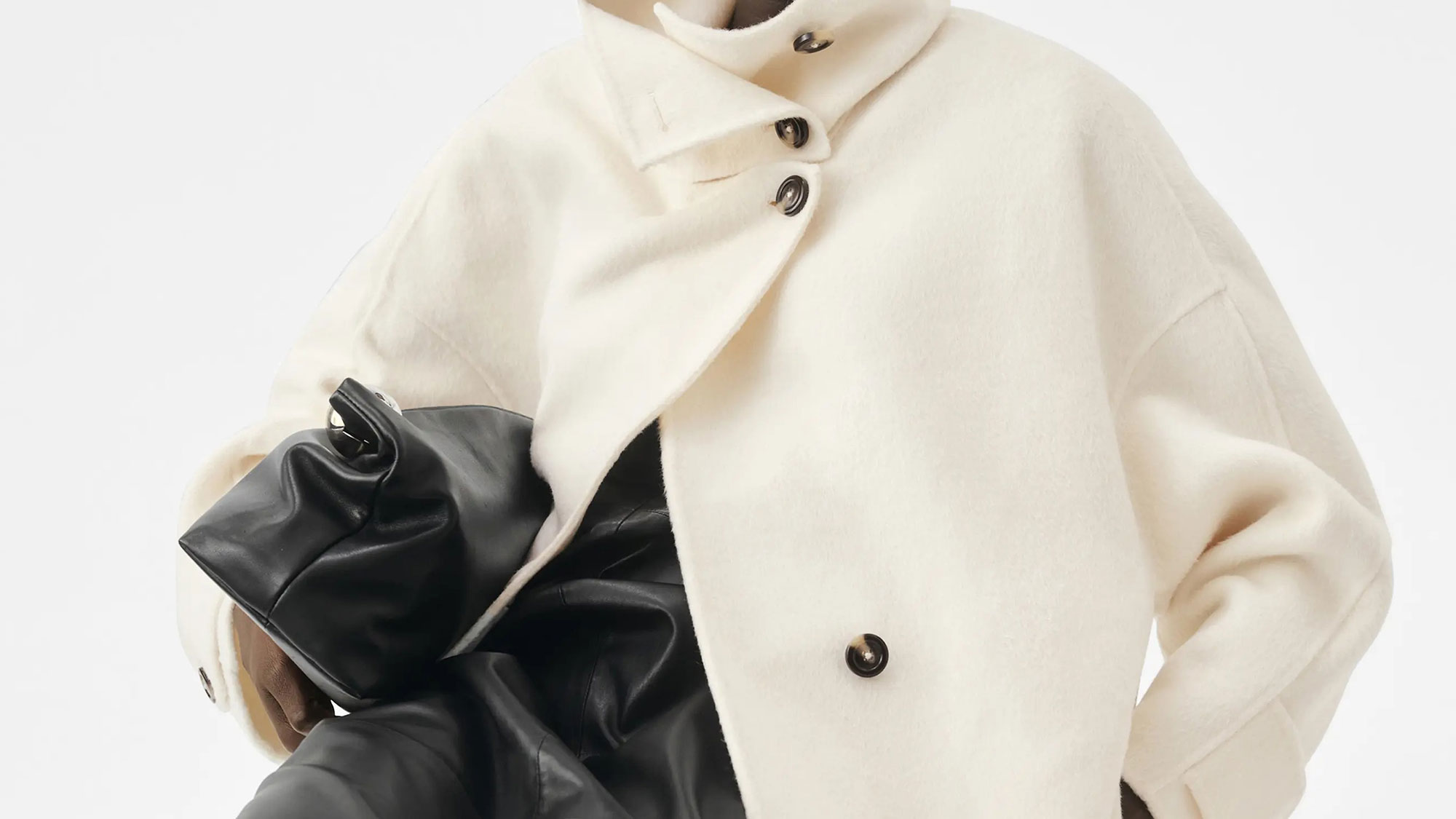 Model wearing a funnel neck coat and leather skirt.