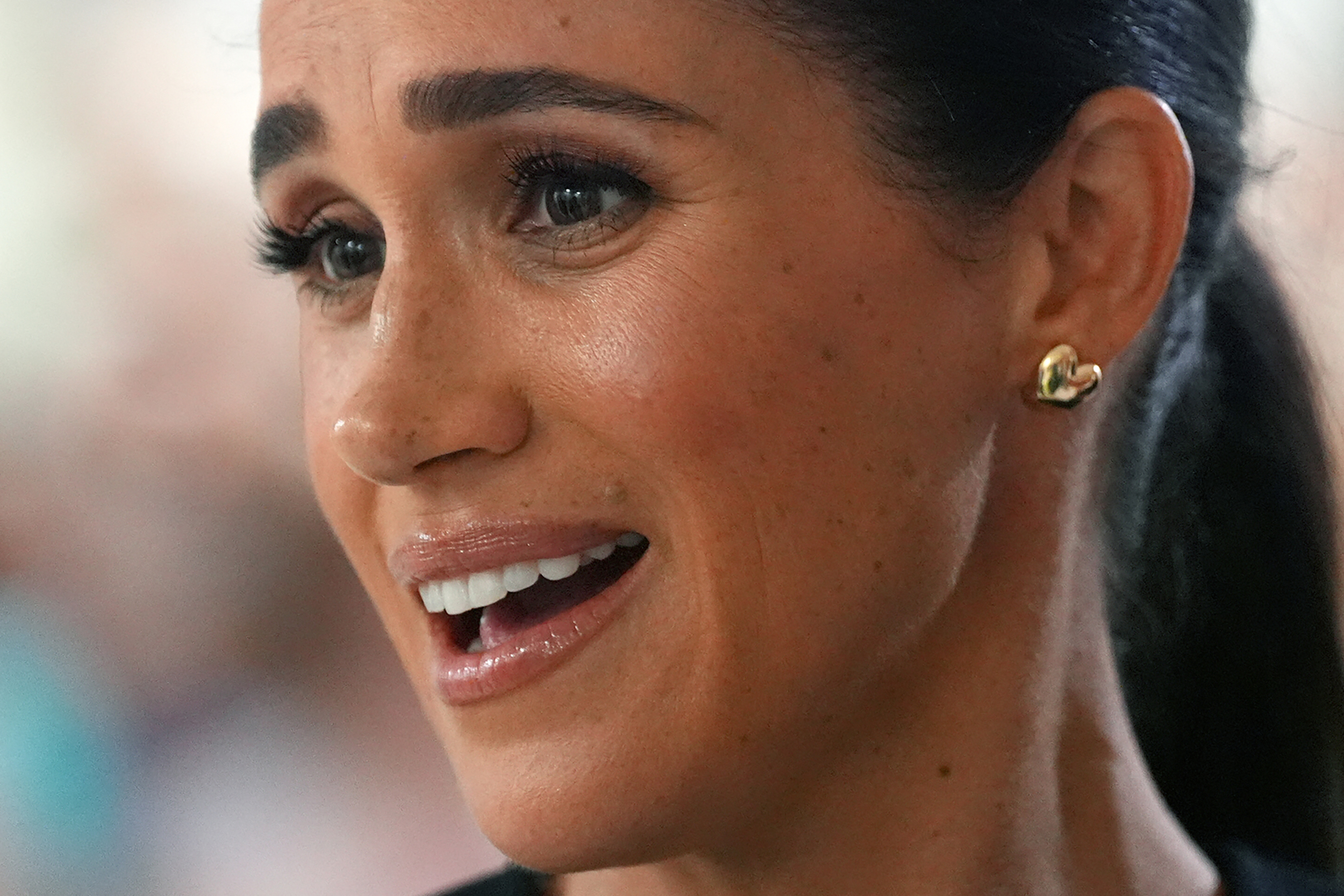 Meghan Markle wearing gold puffy heart earrings
