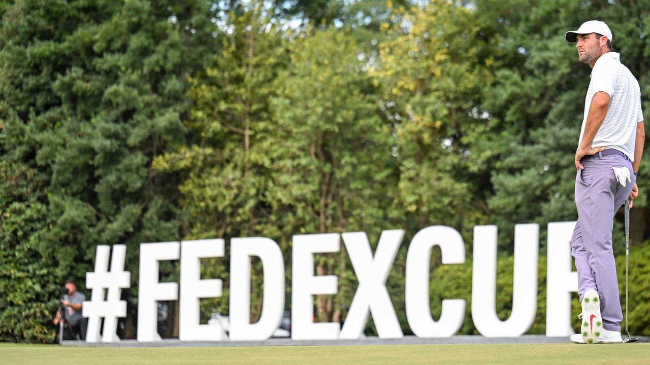 Scottie Scheffler stands in front of a huge FedEx Cup sign at East Lake in 2024