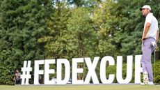 Scottie Scheffler stands in front of a huge FedEx Cup sign at East Lake in 2024