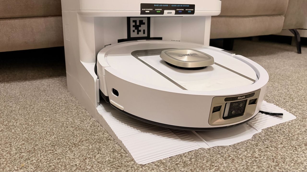 Shark PowerDetect 2-in-1 ThermaCharged NeverTouch photographed on a carpet with docking station