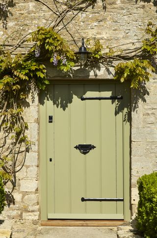 Green front door in stone cottage