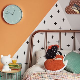 bedroom with toys clock on wall and bed and cushions