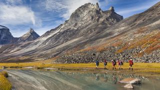Five backpackers hiker across gates of the artic national park in Alaska