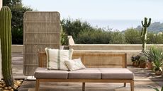 backyard patio space with tables, a couch, and a privacy screen