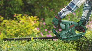 Bosch EasyHedgeCut 45 hedge trimmer in use