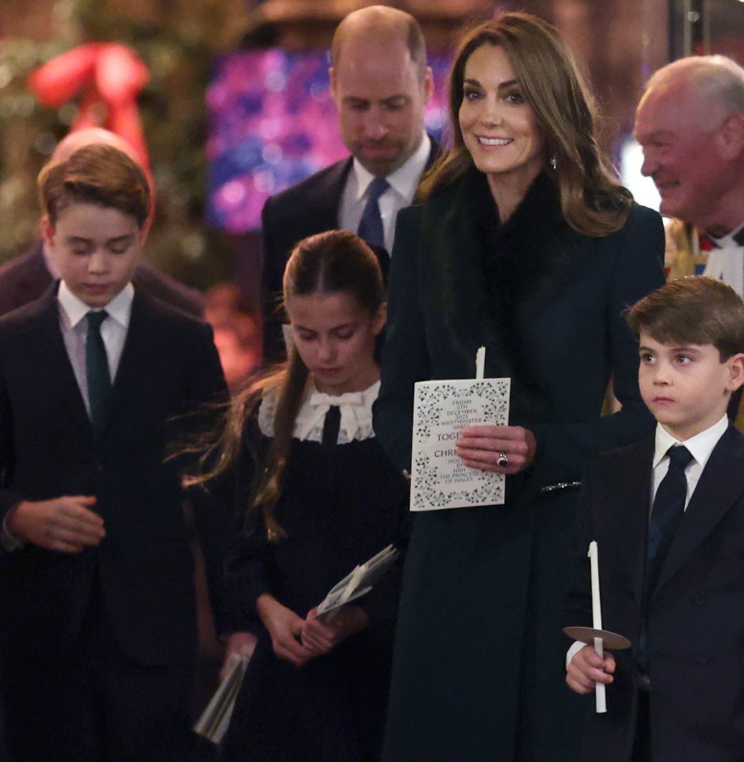 Prince George, Princess Charlotte and Prince Louis holding candles standing in front of Princess kate and Prince William