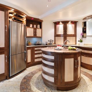 curved kitchen with fridge and wooden cabinets
