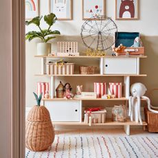 Open shelving unit in a kids room with baskets to keep it organised