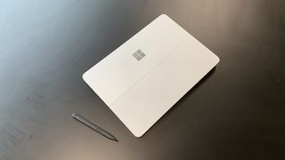 The top cover of the Surface Laptop Studio sitting next to the S Pen.