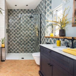 Moroccan inspired small bathroom with terracotta floor tiles and decorative tiled walls