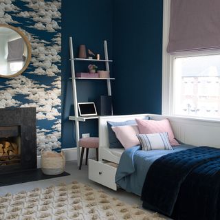 bedroom with dark blue and designed wall and white bed