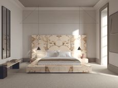 A bedroom with a marble stone bed surround and headboard