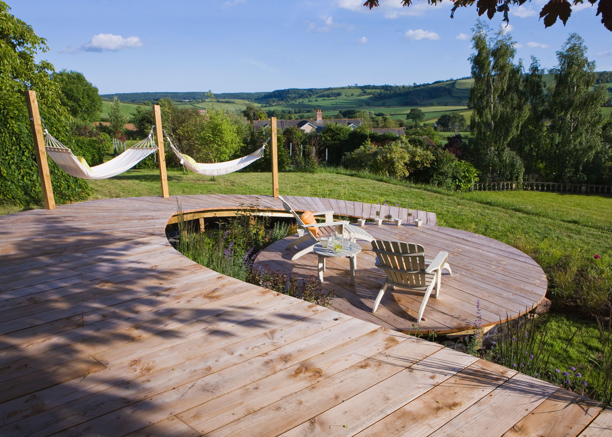 circular wooden deck with garden chairs and view to countryside