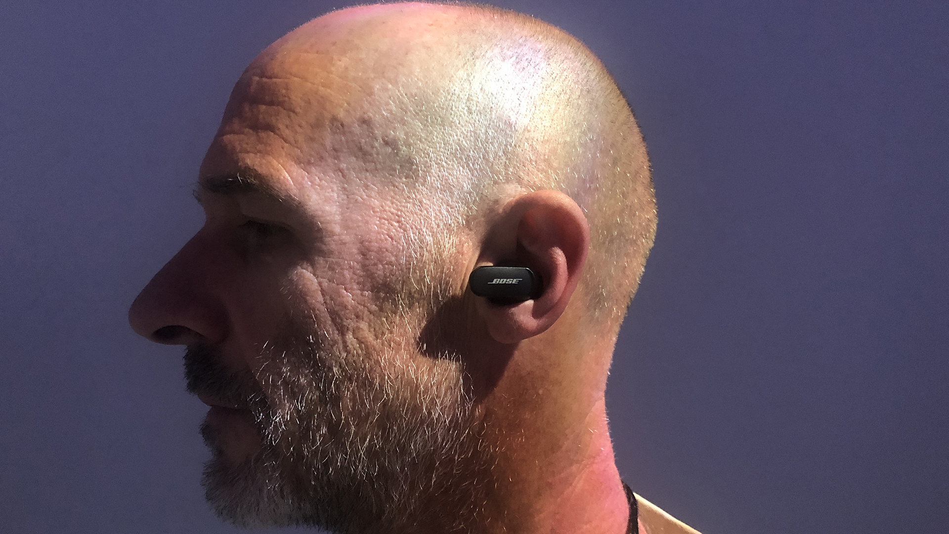 En man som bär ett par svarta Bose QuietComfort Earbuds II