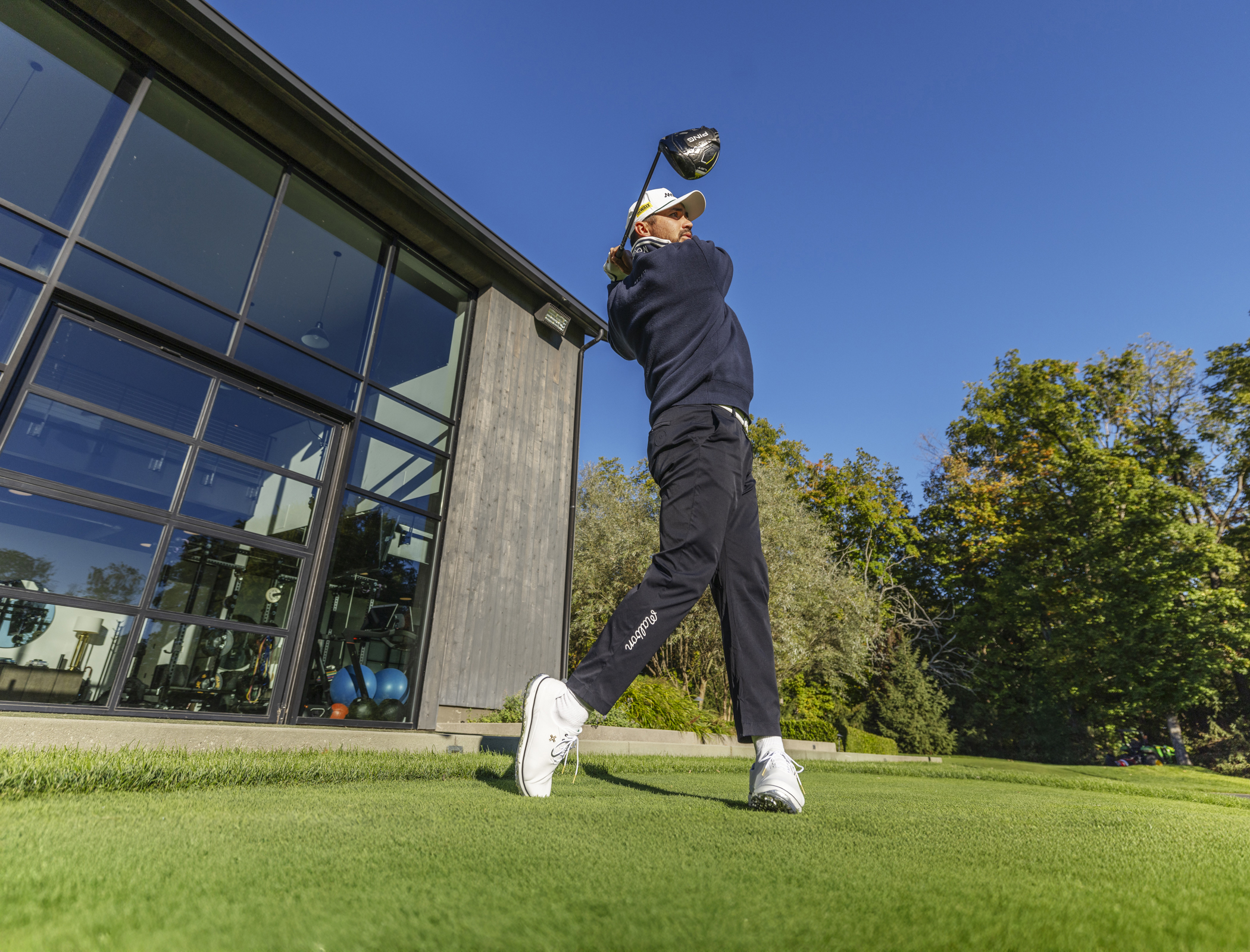 Jason Day hitting golf balls in the PAYNTR Eighty Seven Sc golf shoe