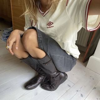 Woman wearing tight brown boots and black shorts.