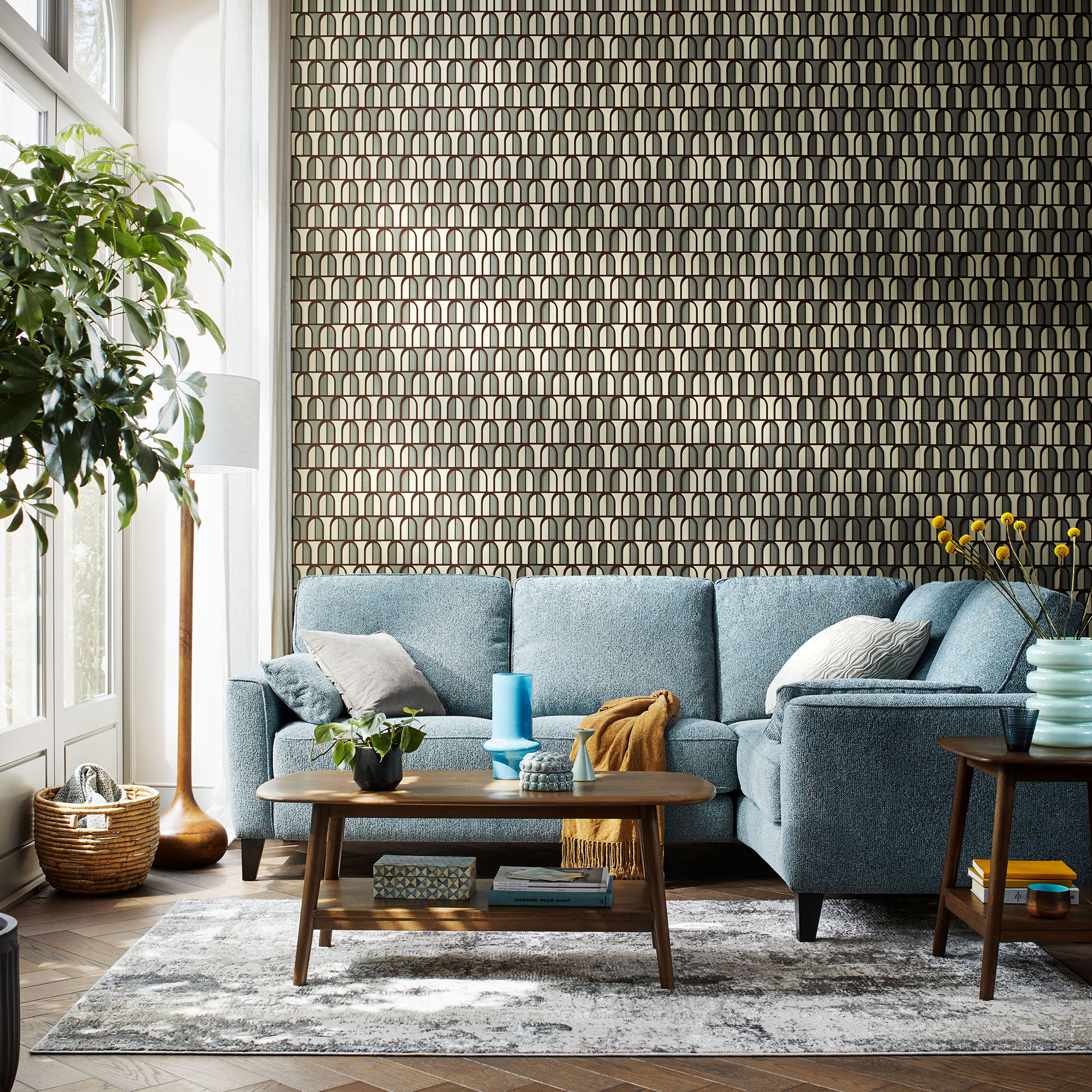 Light blue corner sofa in a mid century style living room with wooden floor and coffee table
