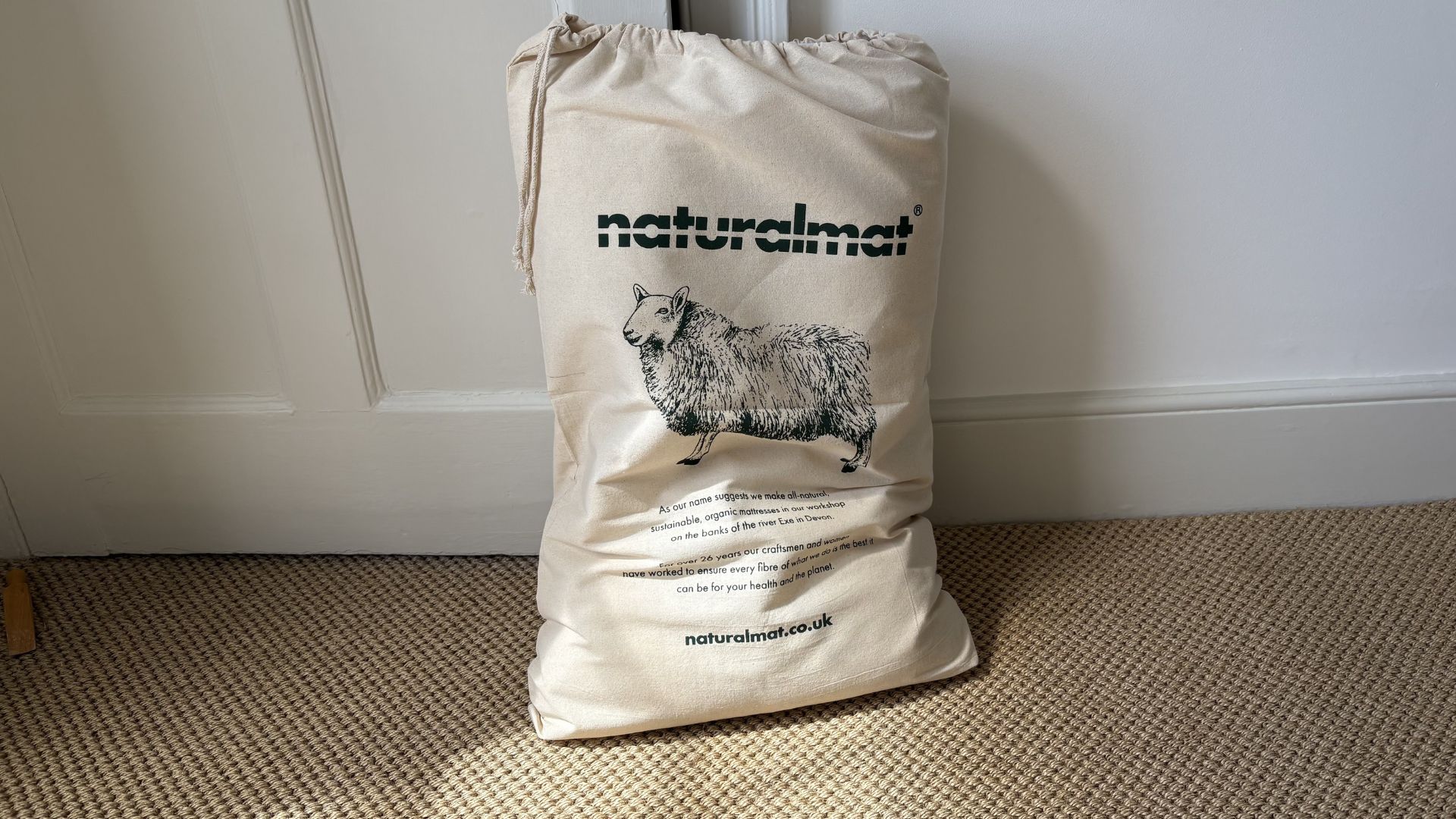 The Naturalmat The Centre Stitched Wool Pillow on a bed