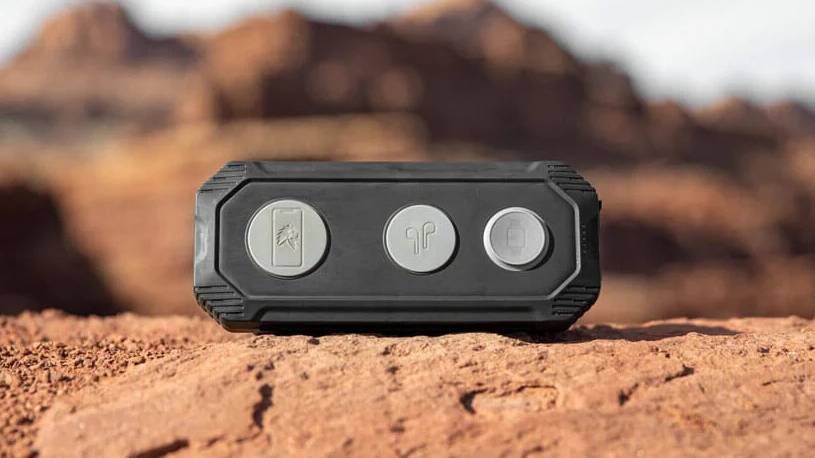 Lion Energy Eclipse Mag wireless charger sitting on a rocky surface with mountain behind.