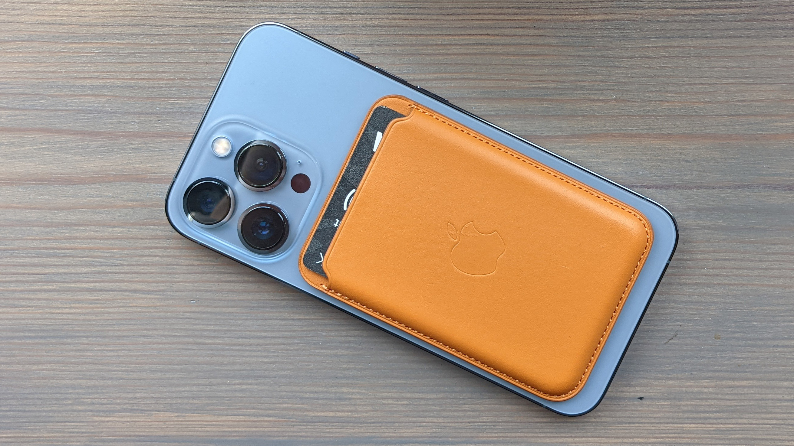 The iPhone Leather Wallet with MagSafe on the back of an iPhone 13 Pro in blue