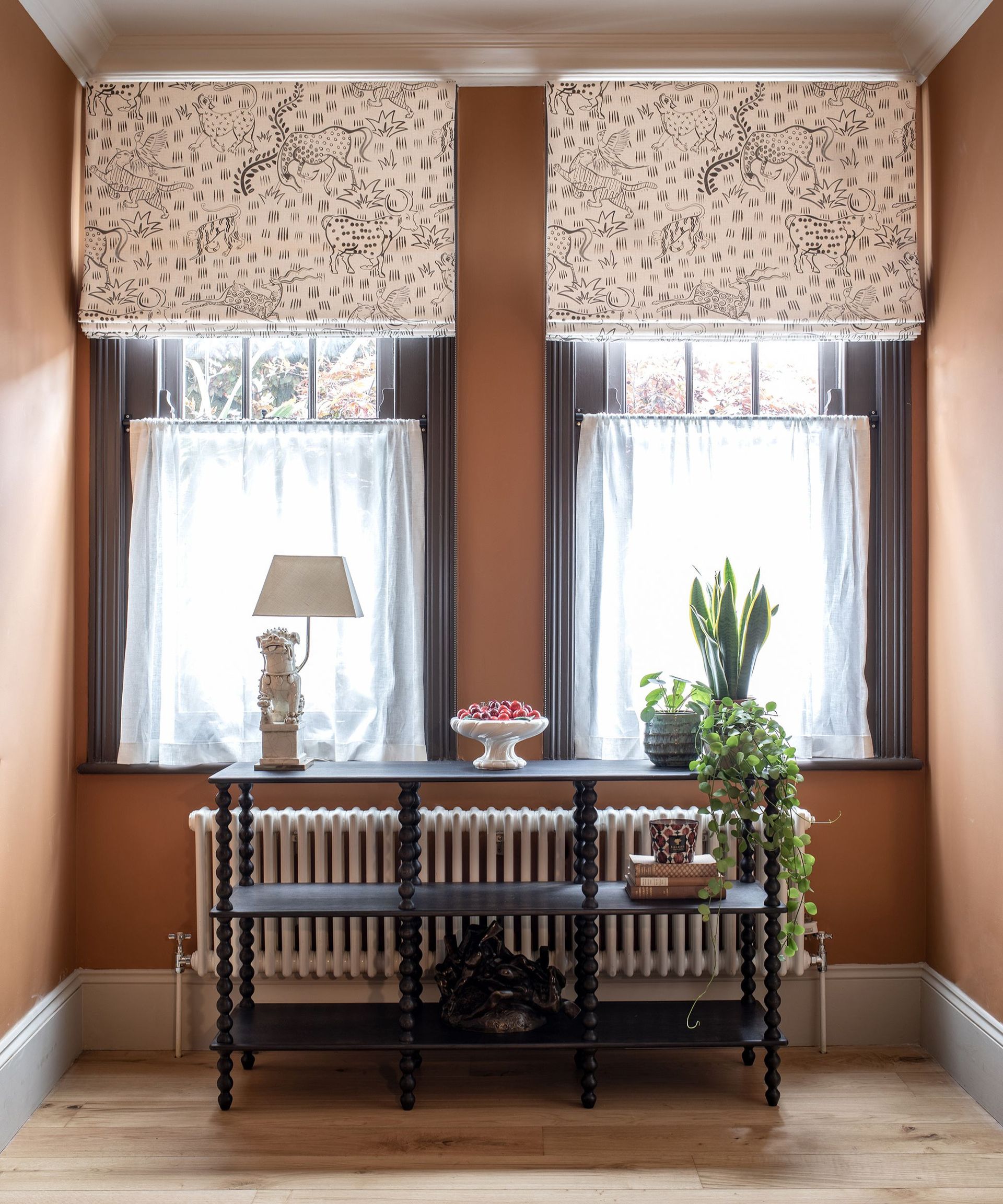 Terracotta hallway with bobbin console, printed roman blinds and cafe curtains