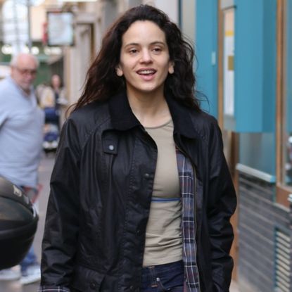 Rosalia wearing a barn jacket, a t-shirt, jeans, and boots while in Paris on March 19