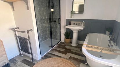 bathroom with roll-top bath, wood look flooring, a jute rug and shower with Art Deco tiles