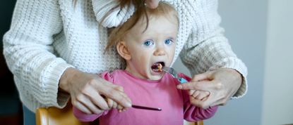 Child being fed a pancake