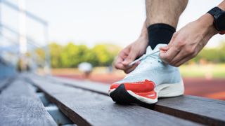 Man tying laces of road running shoes