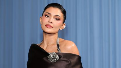 Kylie Jenner across a blue curtain