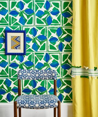 patterned wallpaper with pattern upholstered chair and yellow curtain