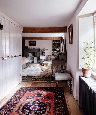 farmhouse bedroom with fitted wardrobes, wooden floor and fireplace