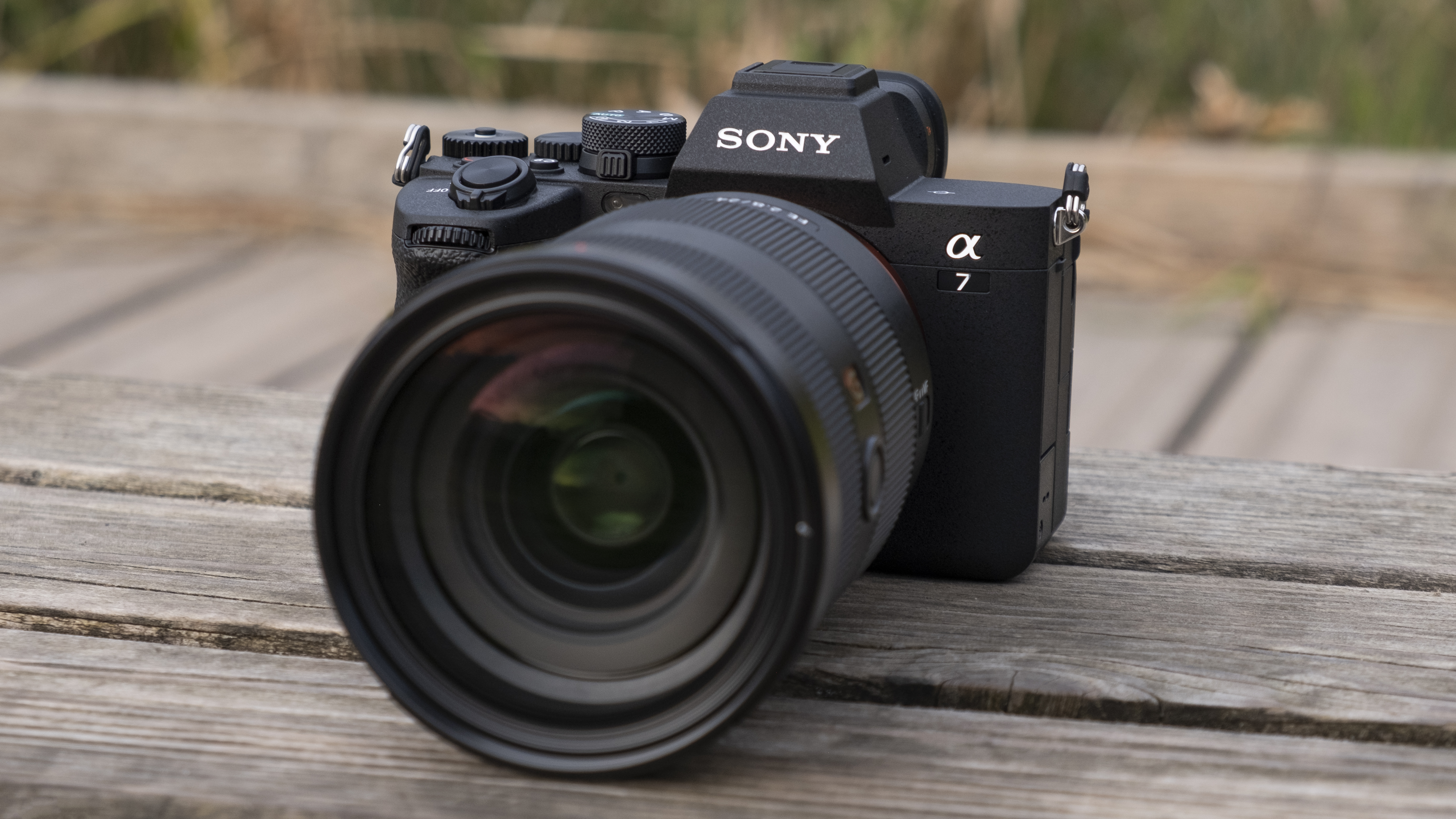 The Sony A7 IV camera sitting on a wooden bench