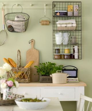 kitchen with olive green wall and rustic grill shelf with wooden table