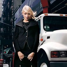 Model posed in front of truck in busy city