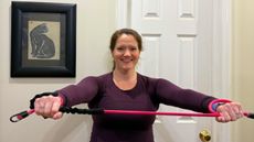 Woman holding exercise band in front of her