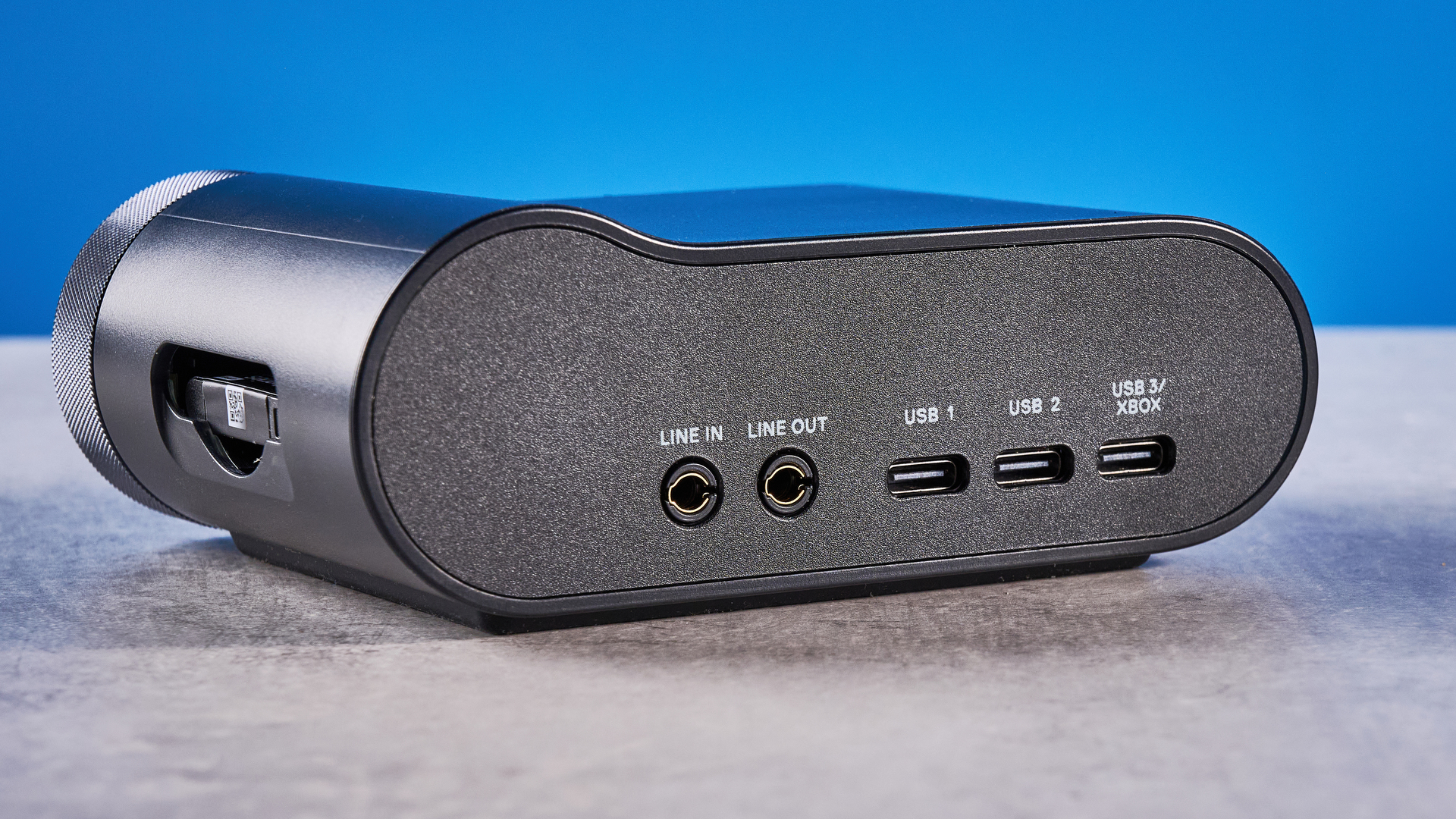 The SteelSeries Arctis Nova Pro Omni on a stone surface against a blue background