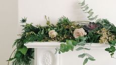 Christmas garland made from foraged pine, fir, eucalyptus, thistle and ivy placed on a mantle