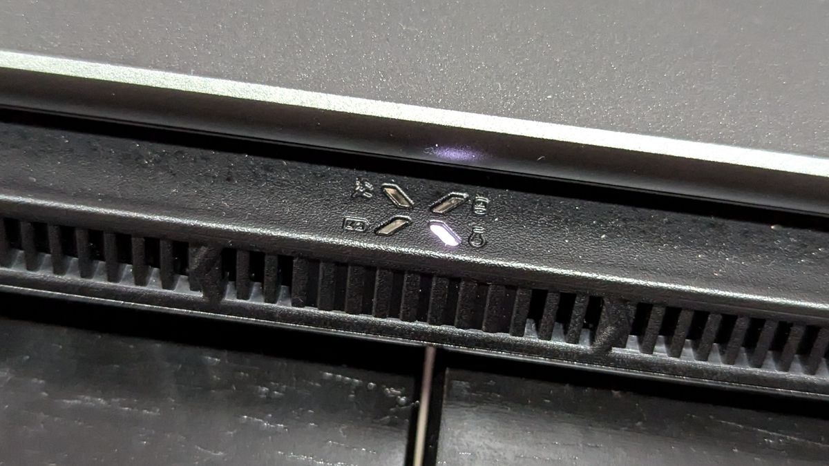 A close up of a small logo near the exhaust vents on a laptop.