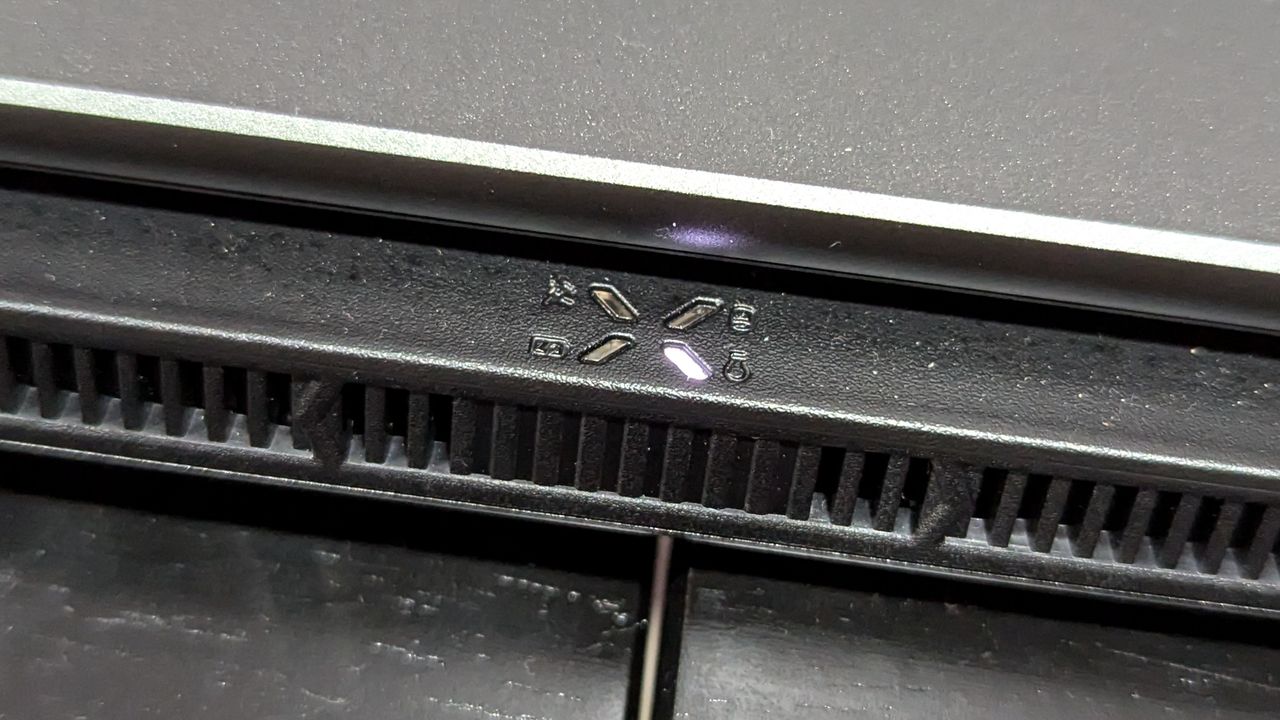 A close up of a small logo near the exhaust vents on a laptop.