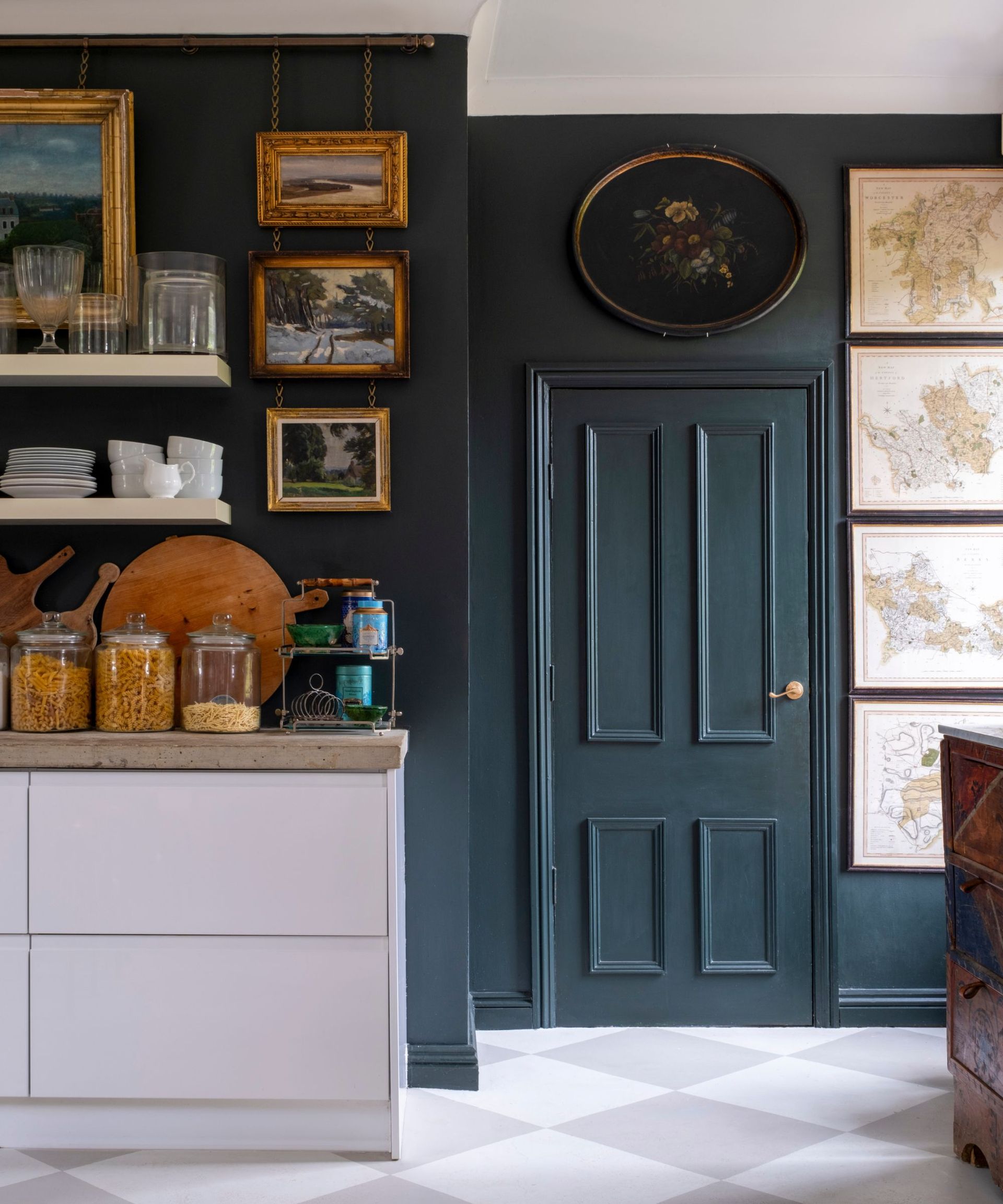 Kitchen with dark blue walls and door with vintage paintings on walls